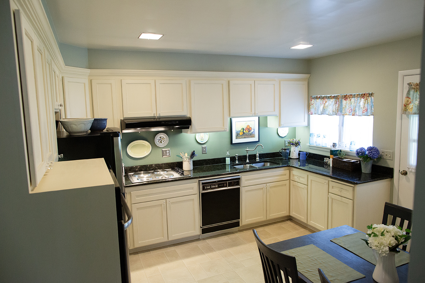 green and white custom kitchen with black countertops